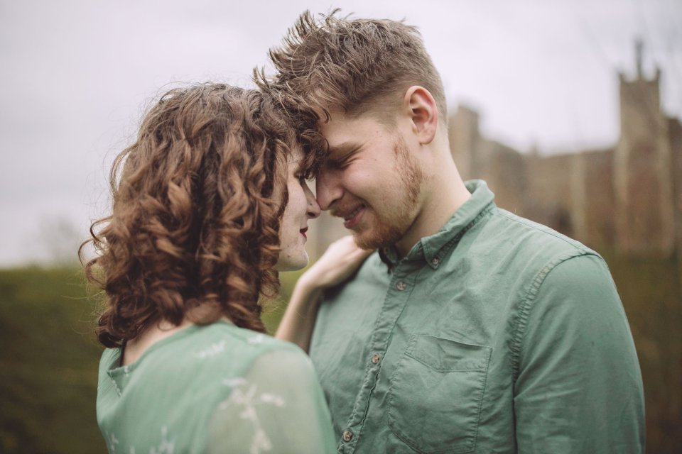 Intimate portrait of a couple in matching green outfits sharing a tender moment.