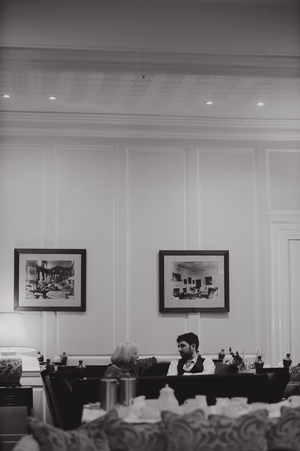 A groom speaks to a woman in Hintlesham Hall drawing room.