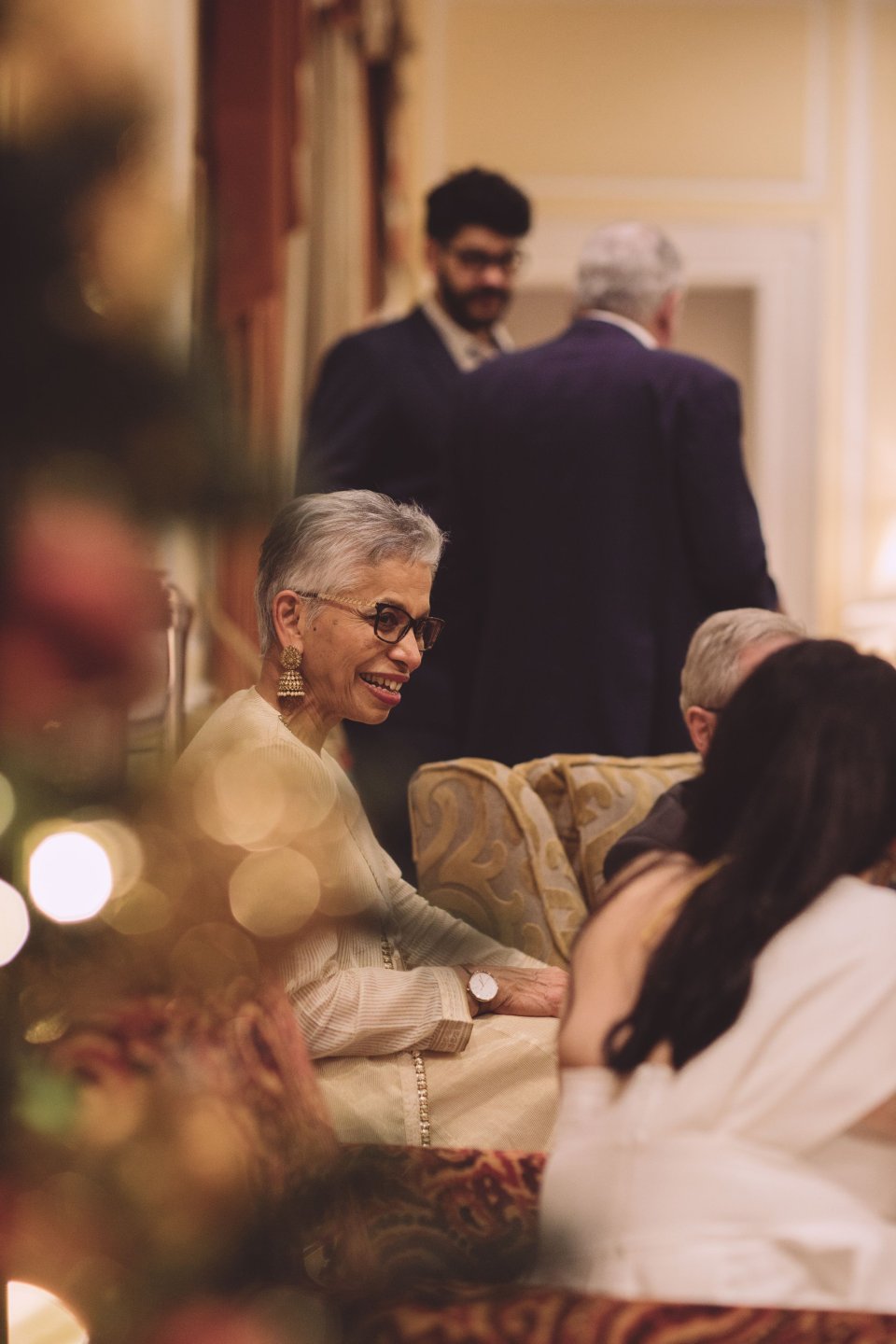 A woman speaks to other wedding guests at a Hintlesham Hall wedding reception.