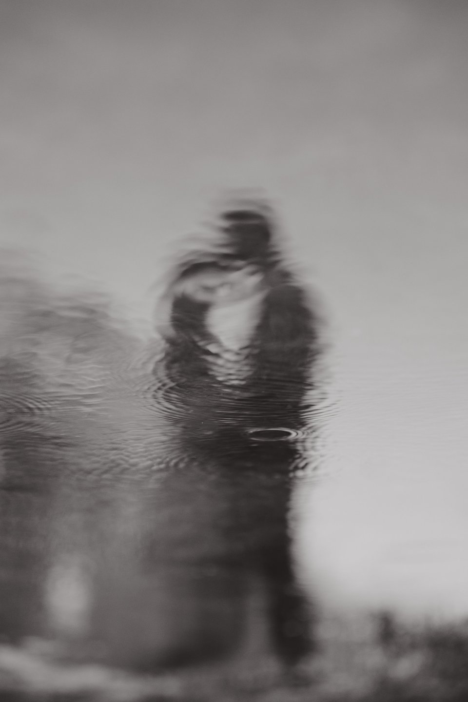 Artistic black and white reflection showing silhouettes in water with a dreamy, distorted effect.