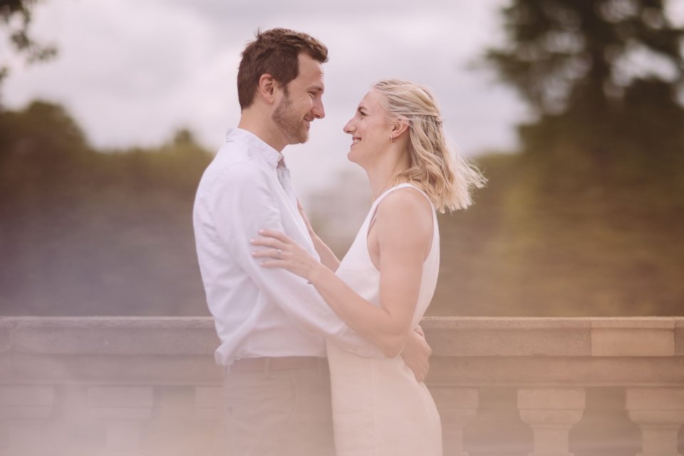 Romantic sunset portrait of a couple in wedding attire embracing on a balcony.
