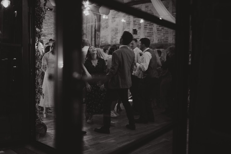 Black and white photo showing people dancing at a suffolk barn wedding