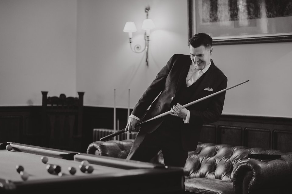 Groomsman playing pool in a stately manor
